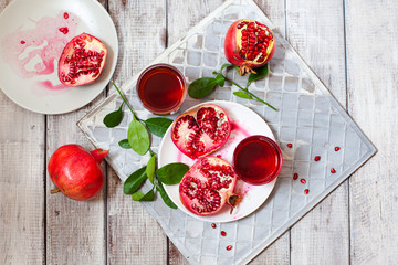 Pomegranate juice with fresh pomegranate fruits on wooden table