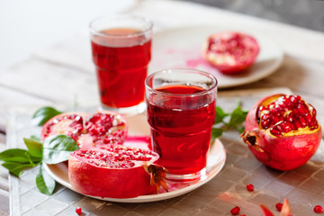 Pomegranate juice with fresh pomegranate fruits on wooden table