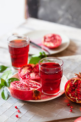 Pomegranate juice with fresh pomegranate fruits on wooden table