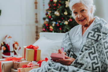Obraz na płótnie Canvas Happy elderly woman is resting at home