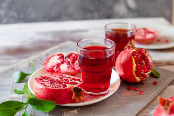 Pomegranate juice with fresh pomegranate fruits on wooden table