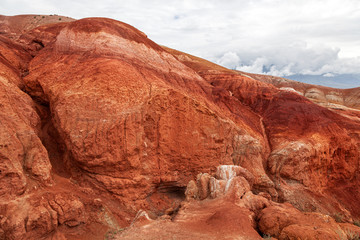 Fototapeta na wymiar A stunning panorama of a mountain chain of peaks, a canyon with red clay, top view. Mars fields in Altai, Russia. fantastic clay castles in the sandy desert of the red canyon