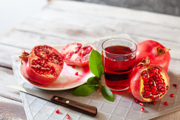 Pomegranate juice with fresh pomegranate fruits on wooden table