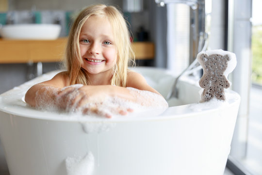 Cute little girl holding hands on the bath