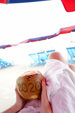  Coconut with the inscription twenty twenty, 2020, on the beach by the sea.