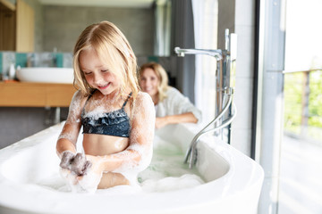 Smiling girl in the foam in the bath