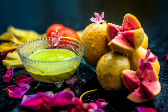Best cheap face mask for tanned skin on wooden surface un a glass bowl consisting of guava leaves paste well mixed with some tomato pulp. Shot with entire ingredients with fantastic colors.