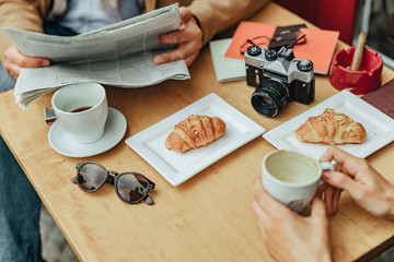 Man and woman sitting at the table with pastries and coffee