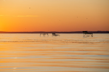 strong sunset at lake balaton with fishing spots fonyód district hungary summer vacation travel relax