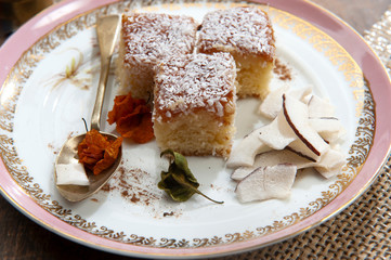 Handmade cake, coconut, condensed milk.Iced, served on plate, light pink border.White background....