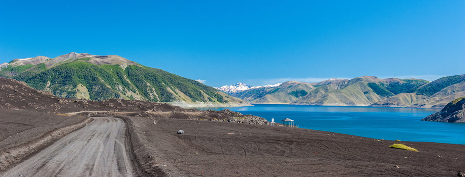 Laguna de La Laja, dirt road and the views of the desert landscape Antuco volcano black volcano desert. Northern Patagonia, Andes, Chile, South America.