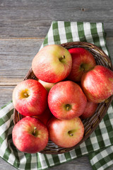 Apples in a basket on a gray wooden background. Autumn harvest