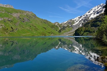 Fototapeta na wymiar Engstlenalp/Engstlensee Switzerland, Schweizer See in den Bergen, Das Wasser spiegelt wunderschöne Berge wider.