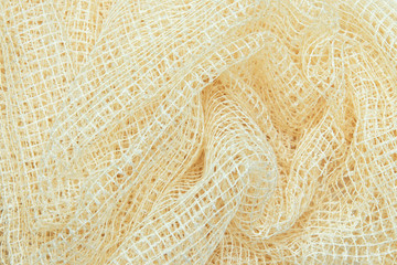 Light fabric texture of delicate yellow closeup draped background.
