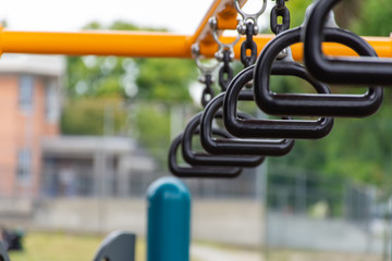 Empty monkey bars at a playground concept looking through at goals and holding on strong preventing falling and maintaining balance.