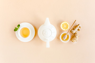 Herbal tea with mint, ginger, lemon, honey and other herbs on yellow background. Flat lay, top view.