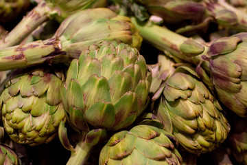 Obraz premium Fresh artichoke piled on the market. Food backgroumd. Harvest