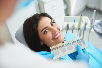 Stomatologist choosing right implants to happy woman