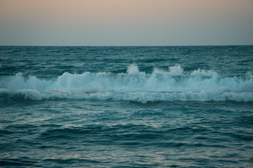 waves crashing in the sunset in greece