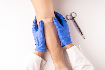 Top view of a doctor healing a injury with a tape or plaster. Medical concept