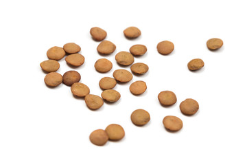 Isolated stack of uncooked lentils on white background from above.