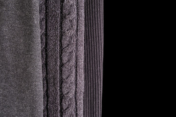 Three different patterns of wool knitting. top view to gray knitwear on black background