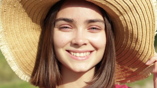 Portrait of a cheerful young girl in a straw hat