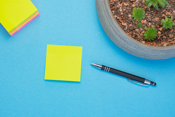 yellow adhesive label beside a black pen against blue surface