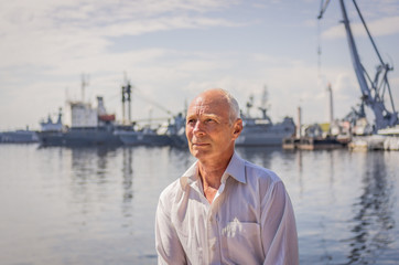 Portrait of an elderly man on the background of the bay