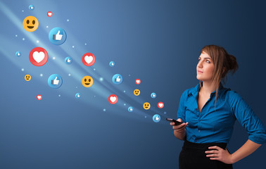 Young person using smartphone with flying social media icons around