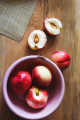 Half and whole nectarines lie in bowl