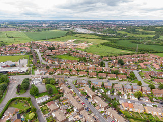 Aerial photo over looking the area of Leeds known as Morley in West Yorkshire UK, showing a typical British hosing estate with fields and roads taken with a drone on a sunny day