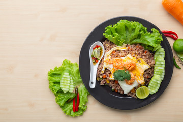 Fried brown rice with shrimp and fried egg in Thai. Prepared and served in a work, Low calories, Healthy food, Top view.
