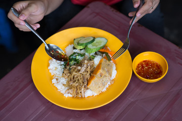 Human eating original Vietnamese com tam broken rice and meat