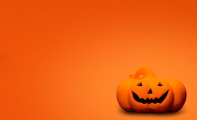 Carved Halloween pumpkin, jack o lantern on an orange background with copy space and room for text