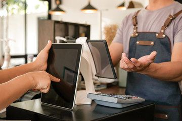Barista is using the screen to receive orders from customers.