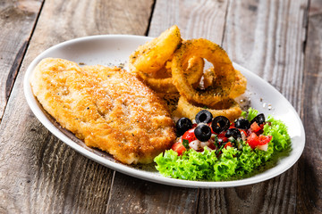 Fried pork chop, onion rings and vegetables