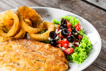 Fried pork chop, onion rings and vegetables