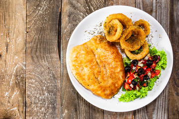 Fried pork chop, onion rings and vegetables