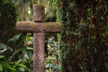 Kreuz aus Holzstämmen auf einem Friedhof