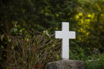 Weisses Kreuz auf einem Grabstein