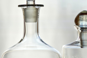 part of two transparent bottles of spirits whiskey gin alcohol white background