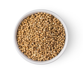 Coriander seeds in white bowl isolated on white background. top view