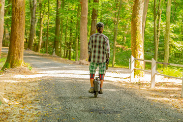 Men in porotective wear riding a forest road with monowheel electrical transport. © Garmon