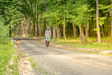 Men in porotective wear riding a forest road with monowheel electrical transport. © Garmon