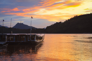 Fototapeta premium Boats on Mekong river with colorful sunset sky in Luang Prabang, Laos