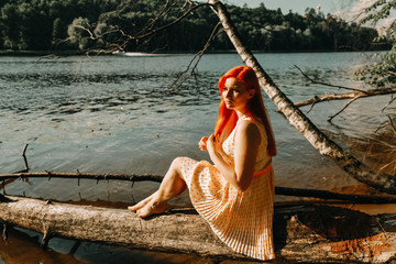 cute redheaded girl walking in the summer hot city park