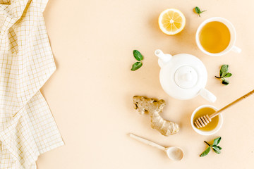 Herbal tea with mint, ginger, lemon, honey and other herbs on yellow background. Flat lay, top view.