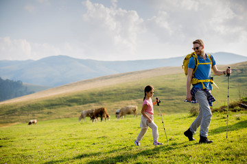 Young father and daughter enjoy hiking on a sunny day