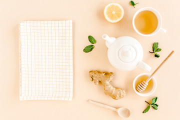 Herbal tea with mint, ginger, lemon, honey and other herbs on yellow background. Flat lay, top view.